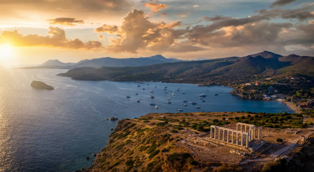 Panoramic view of the Temple of Poseidon at Cape Sounion. Attica, Greece Panoramic view of the Temple of Poseidon at Cape Sounion at the edge of Attica, Greece, with moored sailboats in the bay during sunset time athens greece photos stock pictures, royalty-free photos & images