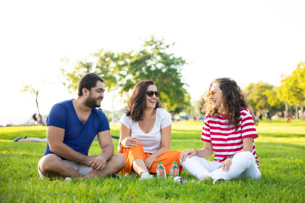 istock Three friends sitting on the grass in the park 1270775092