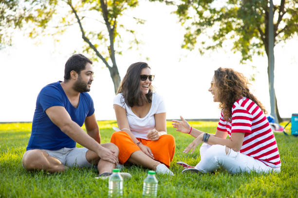 istock Three friends sitting on the grass in the park 1270775095