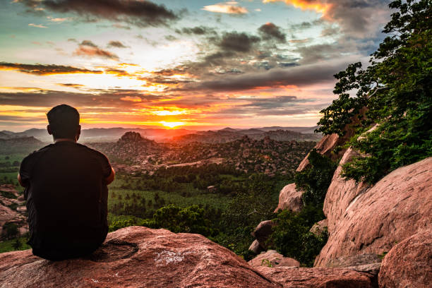 istock man sitting at mountain top watching the sunrise with dramatic sky at morning flat angle shot 1270775256