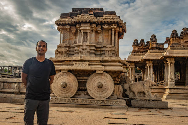 ハンピ石の戦車に立っている男驚くべき青い空とアンティーク石の芸術作品 - indian ethnicity traditional culture architecture karnataka ストックフォトと画像