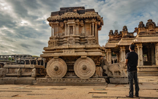 ハンピ石の戦車を目撃した男、驚くべき青い空を持つアンティークの石の芸術作品 - indian ethnicity traditional culture architecture karnataka ストックフォトと画像