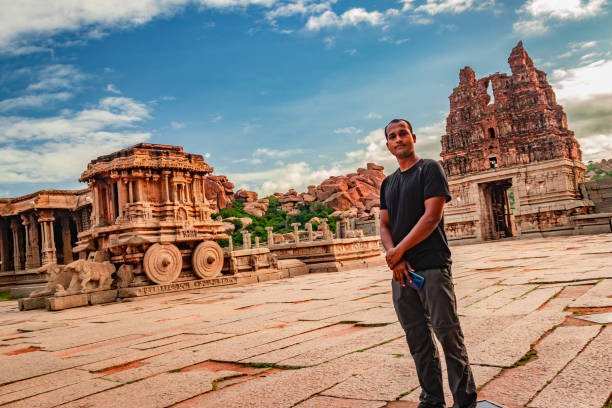 ハンピ石の戦車に立っている男驚くべき青い空とアンティーク石の芸術作品 - indian ethnicity traditional culture architecture karnataka ストックフォトと画像