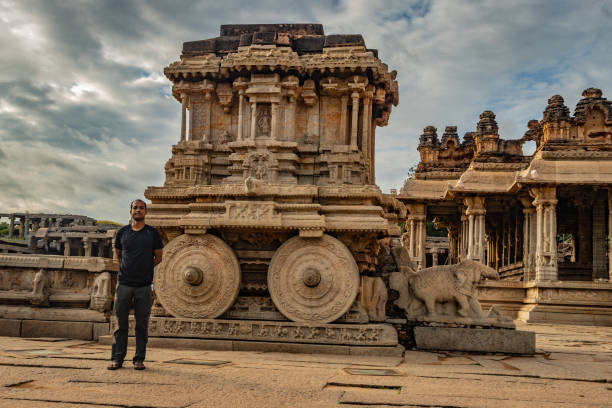 ハンピ石の戦車に立っている男驚くべき青い空とアンティーク石の芸術作品 - indian ethnicity traditional culture architecture karnataka ストックフォトと画像