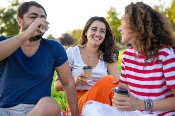 istock Three friends sitting on the grass in the park 1270777201