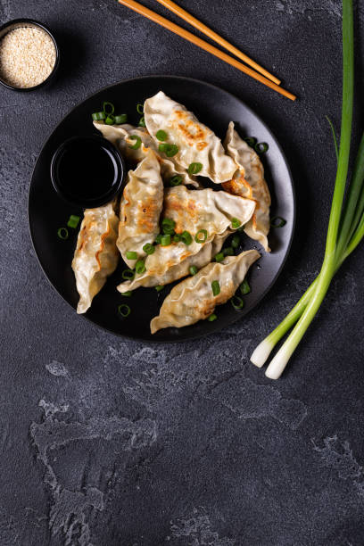 istock Fried dumplings Gyoza on a plate on a gray concrete background 1270783749