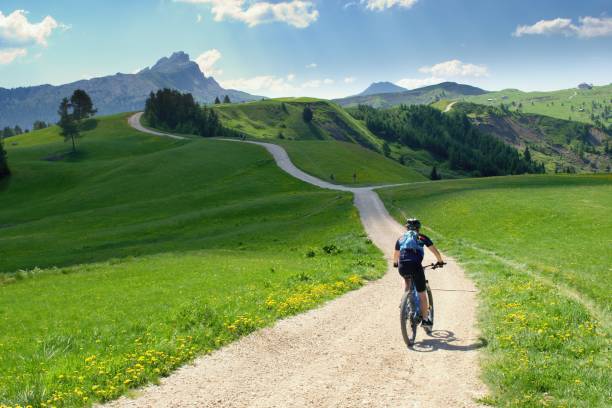 Biker riding scenic path in beautiful summer mountain scenery , Dolomites Italy, European Alps. Biker riding scenic path in beautiful summer mountain scenery , Dolomites Italy, European Alps. dolomites stock pictures, royalty-free photos & images