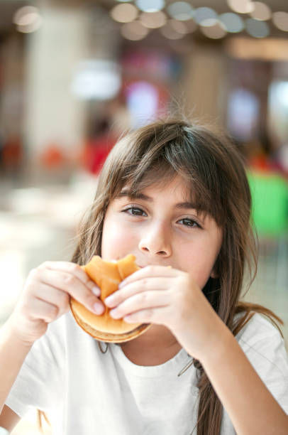 istock Little girl enjoying a burger 1270785736