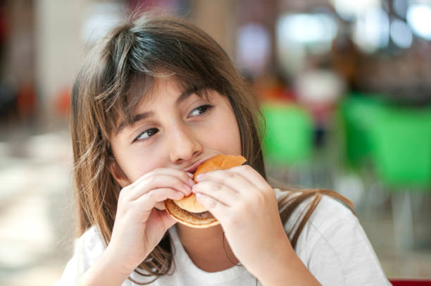 istock Little girl enjoying a burger 1270786336