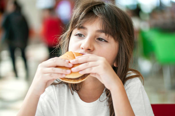 istock Little girl enjoying a burger 1270786525