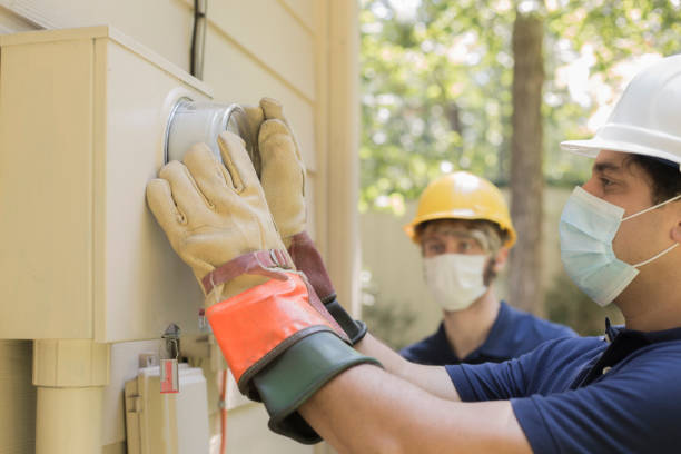 istock Electrical repair men working on outside meter of home. 1270792172
