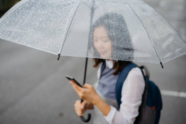 istock Young asian woman using phone on rainy day 1270793405