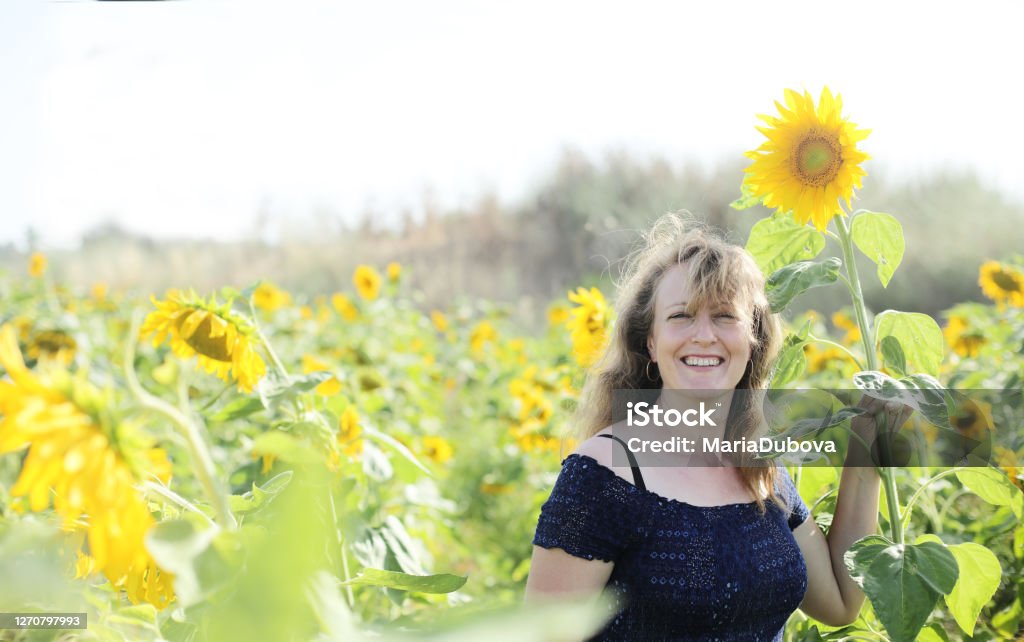 Portrait of happy mature woman  enjoying of freedom in the sunflowers field One Woman Only Stock Photo
