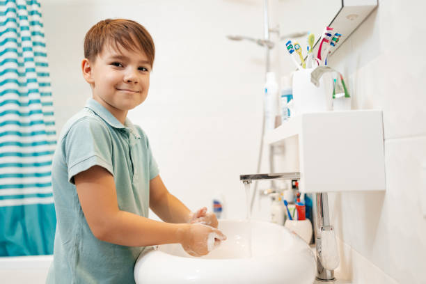 istock Smiling boy wash his hands with soap 1270798136