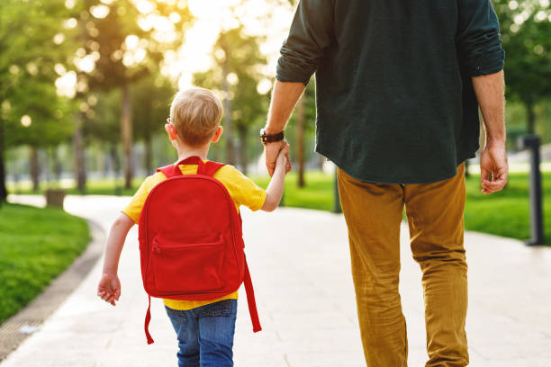 istock Crop man and schoolboy in park 1270799403