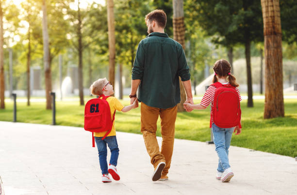 istock Children walking to school with father 1270799467