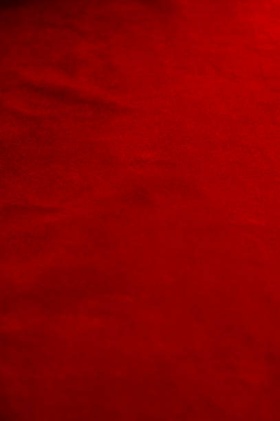 Dark red matte background of suede fabric, closeup. Velvet texture of seamless wine leather. Felt material macro. stock photo