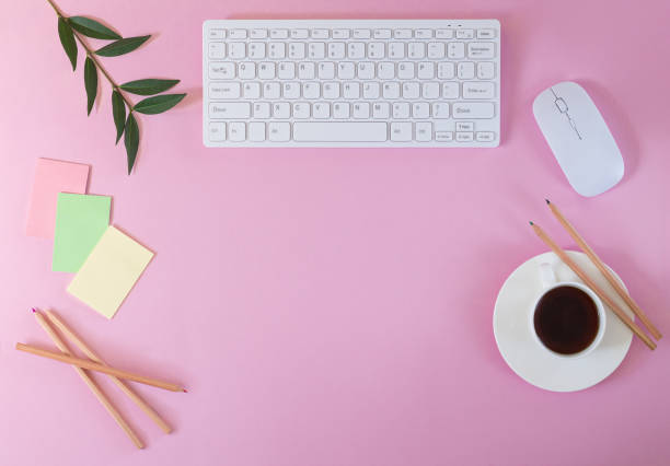 istock Pink office desktop. Modern table with computer keyboard, stickers, pencils and cup of coffee top view 1270801748