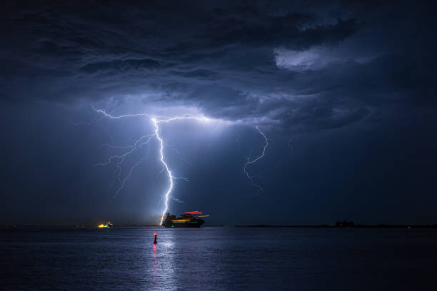 el barco navega a través de un río durante una fuerte tormenta eléctrica - industrial ship flash fotograf�ías e imágenes de stock