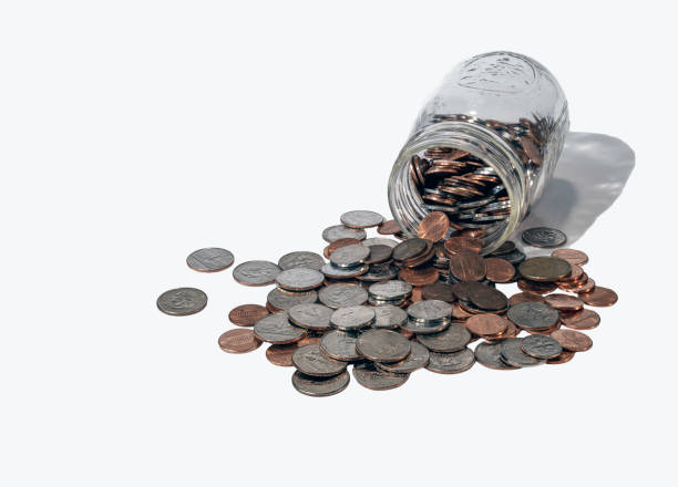 Closeup shot of a shiny copper low value euro coins spilled from a glass jar.