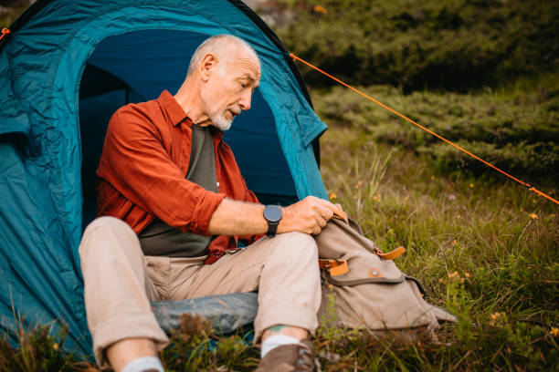istock Senior camper preparing himself for night in tent 1270807933