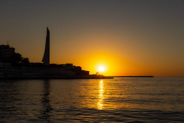 Sunset in Sevastopol over Cape Khrustalny on September 01, 2020. Beautiful orange round sun at sunset. Urban landscape at sunset. Autumn evening in Sevastopol.