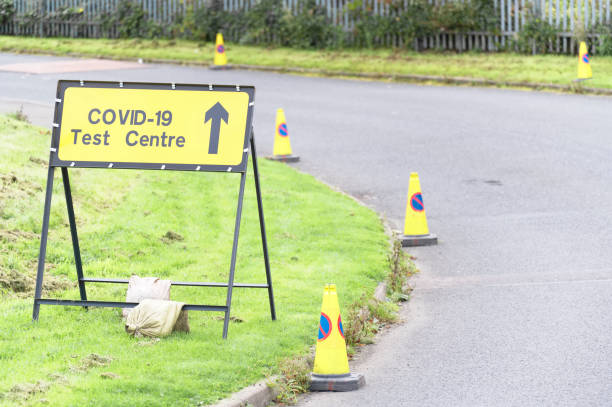 Covid-19 test centre sign at road with traffic cones