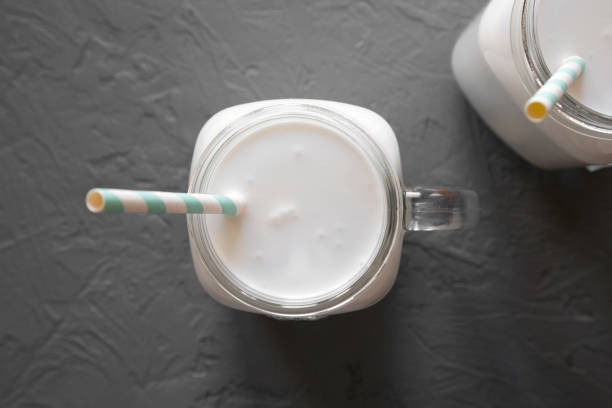 istock Coconut milk in glass jars on gray background, top view. 1270814329