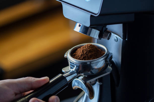 istock coffee grinder grinding coffee pouring into a portafilter 1270815582