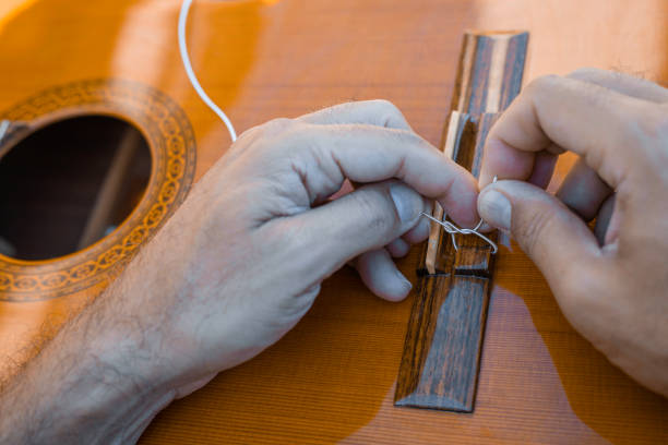 istock Male hands changing the strings of a classical guitar 1270819371