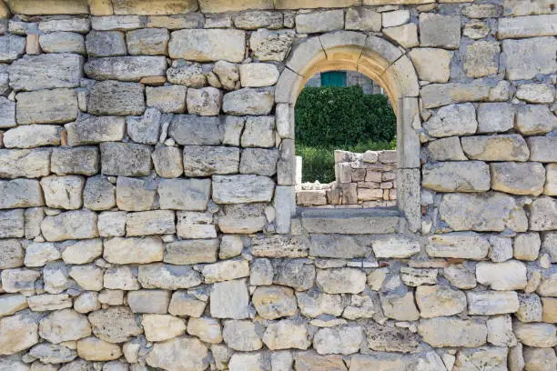 The texture of the ancient wall of stones with a window.