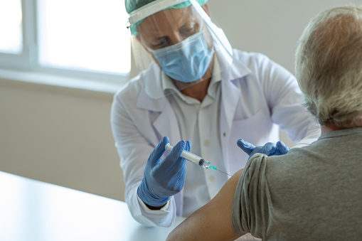 Inyección de la vacuna contra la gripe en el brazo del paciente photo