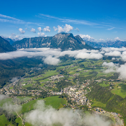 Panorama of the beautiful town Bad Aussee peaking through the clouds in the middle auf the Austrian Alps at sunrise. Nature Reserve. Steiermark. Ausseerland, Salzkammergut. Mountain Sarstein in back. Converted from RAW.