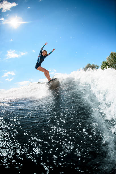 istock view on handsome young woman actively ride surfboard on the wave 1270832053