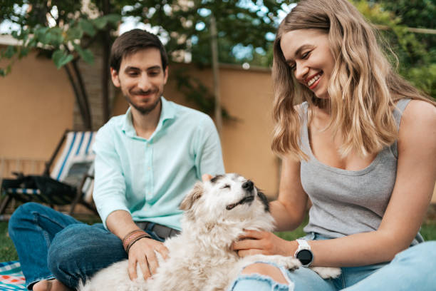 istock Beautiful couple with a dog on the grass 1270832803