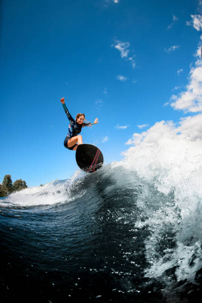 istock Happy woman cool jumping on the wave with surfboard 1270832897