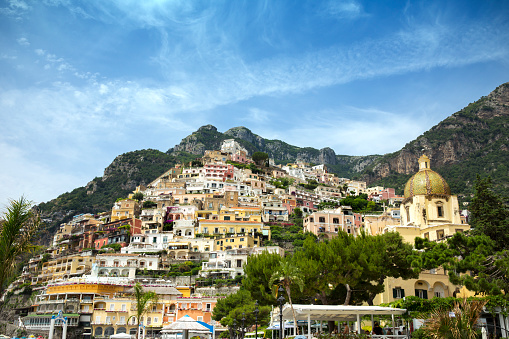 Buildings hugging the hills of the beach town of Positano, on the Amalfi Coast in Italy on a bright sunny day.