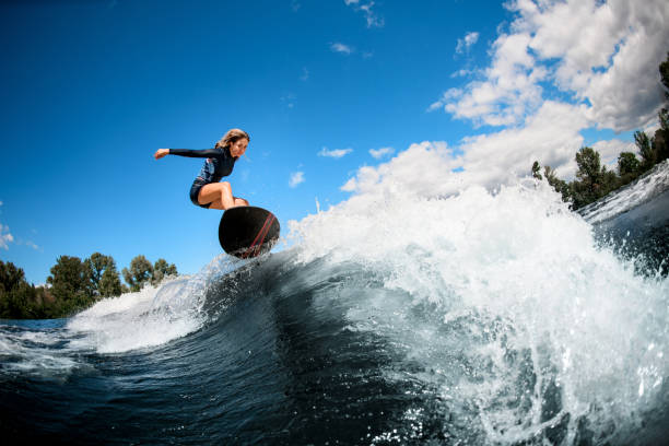 istock woman on surfboard jumping over the wave 1270835267