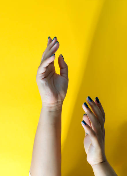 istock Woman's hands with nice manicure against yellow wall. 1270835676