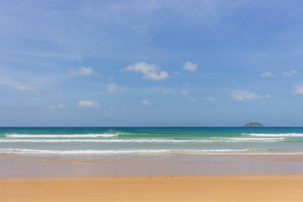 Empty tropical beach on sunny day. Duli beach in Palawan, Philippines. Surf beach. Wide beach with island on background. Travel in Asia. Tropical landscape. Azure water in idyllic lagoon. Paradise nature.