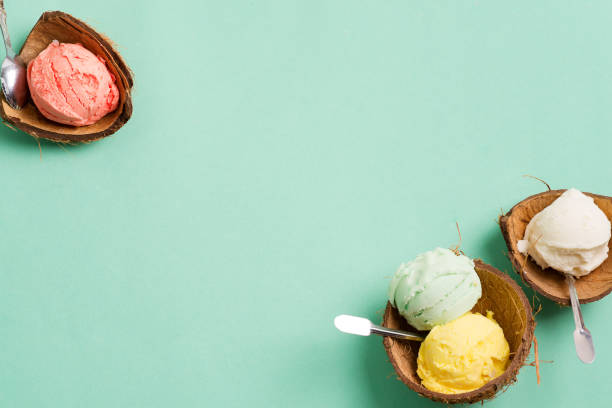istock Coconut shells with fresh natural colorful ice-cream on a light green background. 1270842281