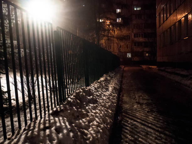 istock paved path by the light of a lantern at night in winter 1270844155