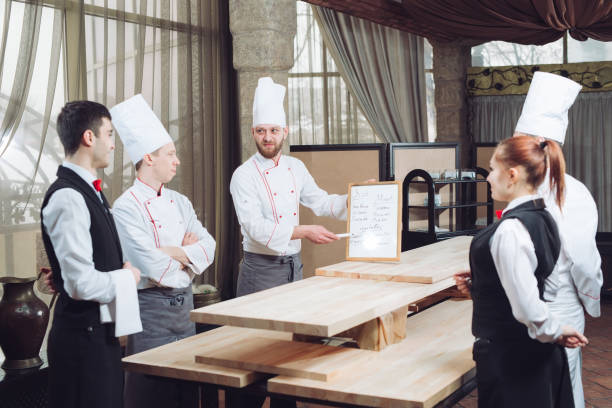 istock Head Chef and his staff in kitchen. interacting to in commercial kitchen. 1270846850