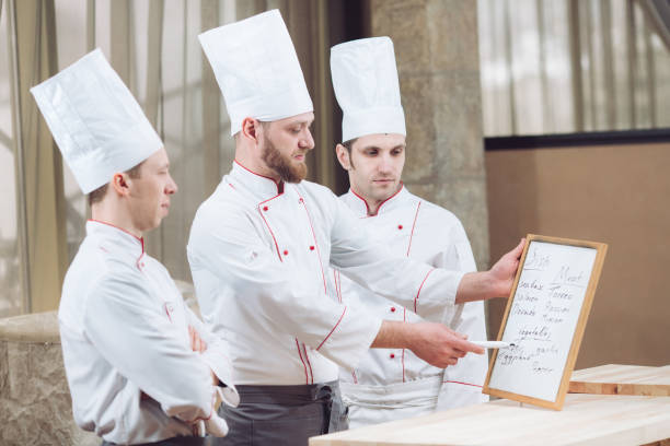 istock Head Chef and his staff in kitchen. interacting to in commercial kitchen 1270846946