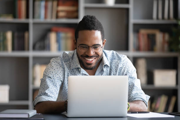 istock Laughing African American man using laptop, looking at screen 1270850593