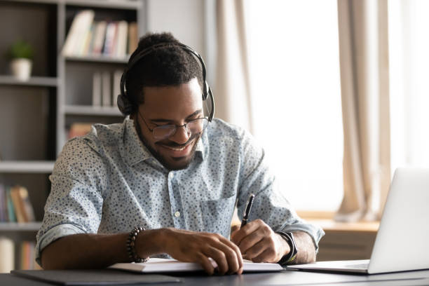 istock Smiling motivated African American student listening to lecture, writing notes 1270850617