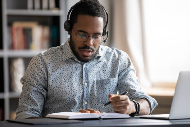 istock Serious focused African American man wearing headphones writing notes 1270850624