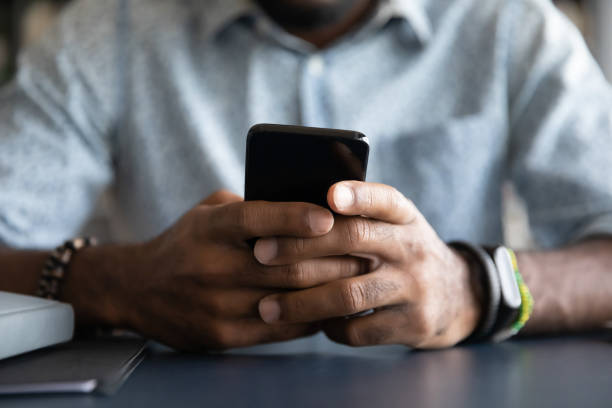 istock Close up African American man using smartphone, sitting at desk 1270851159