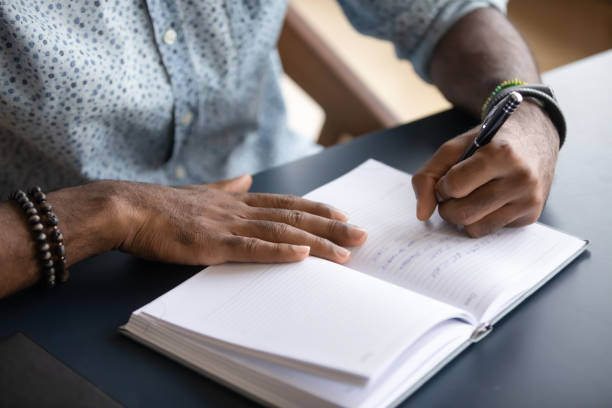 istock Close up African American businessman writing in notebook, making notes 1270851161