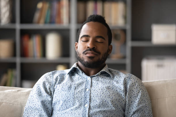 istock Close up peaceful African American man sleeping, sitting on couch 1270851170
